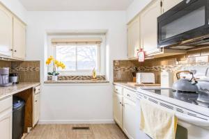 a kitchen with white cabinets and a sink at SmartHome- Omaha Homestay with EV Charging in Omaha