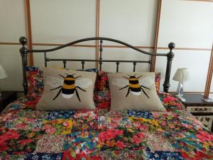 Una cama con dos almohadas con abejas. en Grovewood House Retreat en Kirkbean