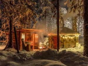 a cabin in the snow with lights on at Cozy a-frame in the woods in Enontekiö