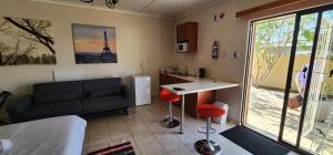 eine Küche und ein Wohnzimmer mit einem Sofa und einem Tisch in der Unterkunft BluePalms Guesthouse in Swakopmund