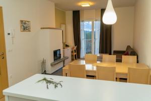Apartmajska hiša Breza في Ribnica na Pohorju: مطبخ وغرفة معيشة مع طاولة وكراسي