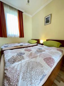 a bedroom with two twin beds in front of a window at Appartement Kastelo Teraso in Zalacsány +36 photos