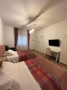 ein Hotelzimmer mit 2 Betten und einem Schreibtisch in der Unterkunft Zelia Rooms in San Ferdinando