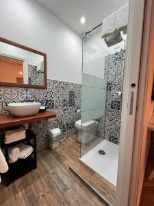 ein Bad mit einer Glasdusche und einem Waschbecken in der Unterkunft Zelia Rooms in San Ferdinando