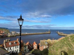 una luz de la calle con vistas a un cuerpo de agua en Sandside Retreat, en Whitby