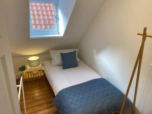 Habitación pequeña en el ático con cama y ventana en Sandside Retreat, en Whitby