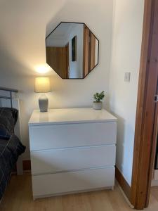 a dresser with a lamp and a mirror on a wall at Studio apartment 3a in the Center of Norwich in Norwich +9 photos