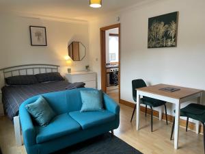 a living room with a couch and a bed and a table at Lovely Studio Apartment in the Center of Norwich in Norwich