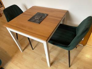 una mesa de madera con 2 sillas y un libro sobre ella en Lovely Studio Apartment in the Center of Norwich en Norwich