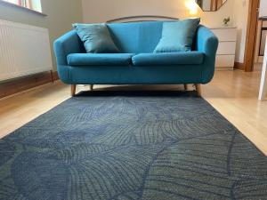 a blue couch in a living room with a blue rug at Studio apartment 3a in the Center of Norwich in Norwich