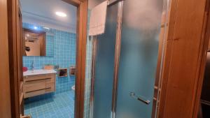 ein Bad mit einer Dusche und einem Waschbecken in der Unterkunft Studio Apartment Ariston in centro a Cortina in Cortina d'Ampezzo