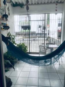 uma rede em uma sala com mesa e cadeiras em BARRA - 3 Quartos / 3 Banheiros - Amplo, Aconchegante e Artesanal em Salvador