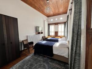 a bedroom with two beds and a desk and a television at Kerem ile Aslı Butik Hotel in Melikgazi