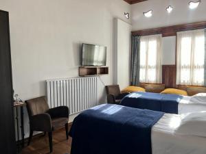 a hotel room with two beds and a flat screen tv at Kerem ile Aslı Butik Hotel in Melikgazi