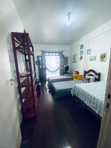 1 dormitorio con 2 camas y estante para libros en BARRA - 3 Quartos / 3 Banheiros - Amplo, Aconchegante e Artesanal, en Salvador