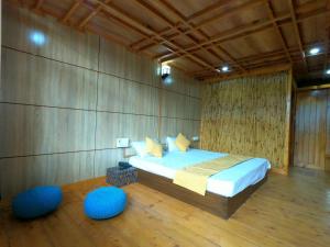 1 dormitorio con 1 cama y 2 reposapiés azules en Hotel Mountaineers Saga, en Nārkanda