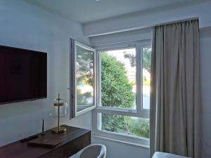 a room with a window with a desk and a television at Luxury apartment Galant 1 in Split