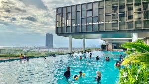 eine Gruppe von Menschen, die in einem Schwimmbecken schwimmen in der Unterkunft Bali Residence with Living Hall Melaka in Malakka