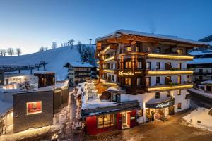 a hotel in the mountains with snow on the ground at Hotel Kendler in Saalbach-Hinterglemm