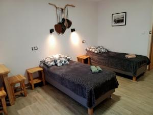 a bedroom with two beds and a table with a guitar on the wall at Wetlina Poza Trasą in Wetlina