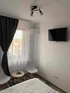 a bedroom with a bed and a tv and a window at Serin Blaxy Studio in Mangalia