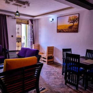 sala de estar con sofá, mesa y sillas en OCTA HOMES en Kampala