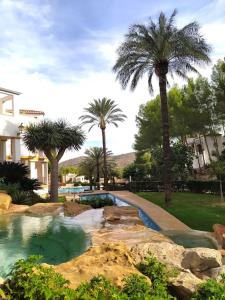 una piscina en un patio con palmeras en La casa de las Palmeras, en Muntanya la Sella