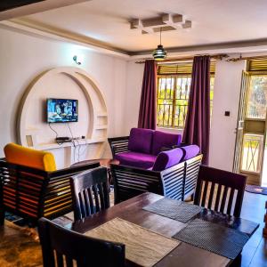 ein Wohnzimmer mit einem Tisch und Stühlen in der Unterkunft OCTA HOMES in Kampala