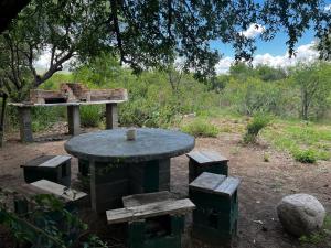 uma mesa de piquenique e um banco num parque com uma mesa e uma mesa em La isla em San Marcos Sierras