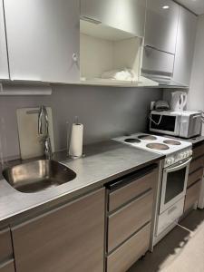 cocina con fregadero, fogones y microondas en apartment en Lappeenranta