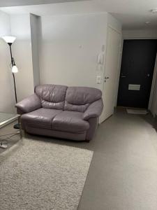 um sofá castanho numa sala de estar com um candeeiro em apartment em Lappeenranta