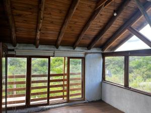 um quarto vazio com janelas e tectos em madeira em La isla em San Marcos Sierras