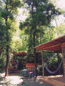 a patio with a hammock and a table and chairs at TIERRA FÉRTIL ECO POSADA in Santa Ana