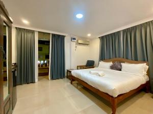 a bedroom with a large bed with blue curtains at Nagas Hotel Satyavati Morjim in Morjim