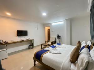 モージムにあるNagas Hotel Satyavati Morjimのベッドとテレビが備わるホテルルームです。