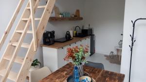 uma cozinha com uma mesa de madeira com um vaso de flores em Domek Wonkopianka em Grywałd