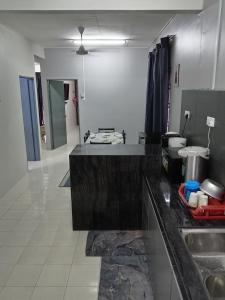 eine Küche mit einer Spüle und einer Arbeitsplatte in der Unterkunft RizqFateh Homestay in Keluang