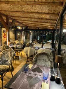 a dining room with tables and chairs and windows at Pension & Restaurant Krakonoš in Harrachov