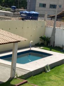 a small swimming pool in a yard next to a building at POUSADA RECANTO DULE in Guarapari