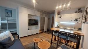 Una sala de estar con un sofá y una mesa con sillas. en Apartman Funn5 - ApartHotel Vucko - private host, en Jahorina
