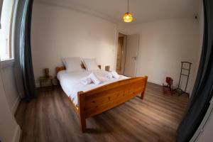 una camera da letto con un grande letto con lenzuola bianche di Le Cocon d'Elisadonna - Centre ville ad Annecy