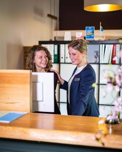 two women standing in front of a counter at Landgoedhotel Woodbrooke Barchem in Barchem