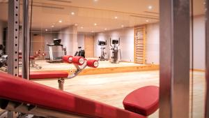 - une salle de sport avec des équipements rouges dans l'établissement Hôtel Le Diamond Rock, à Tignes