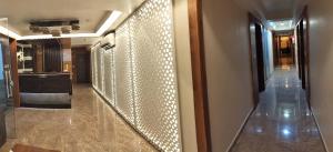 a hallway with a wall covered in lights at HOTEL RJ RESIDENCY in Ahmedabad