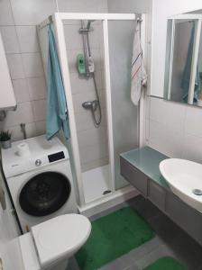 a bathroom with a washing machine and a sink at Cozy Apartment near tram station in Zagreb