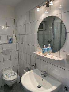 uma casa de banho com um lavatório, um WC e um espelho. em MeerLeev - Panoramablick em Schillig