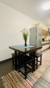 a kitchen with a table with a vase of flowers on it at Charming two- bedroom house in Bucharest