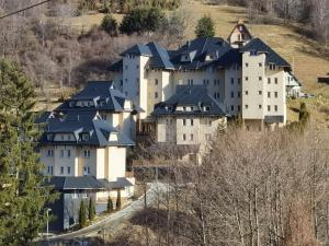 a large white building with black roofs on a hill at WEGA Star Apartmani in Brzeće
