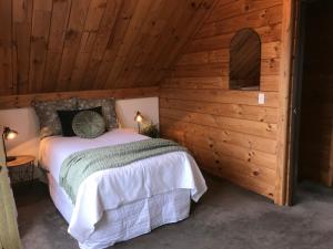 a bedroom with a bed in a wooden cabin at Comfort and Style in this Petone Townhouse in Lower Hutt