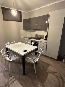 a kitchen with a table and chairs and a stove at APPARTAMENTO IL RESTAURO in Cuneo
